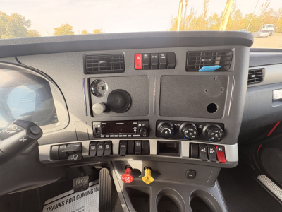 Kenworth T680 dashboard center console with switches, gauges, and climate controls visible; ignition keys red/yellow located below; stereo head unit present.