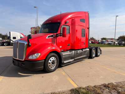 Kenworth T680 sleeper cab truck in red, front three-quarter view with large chrome grille, dual front wheels, and aerodynamic mirrors.