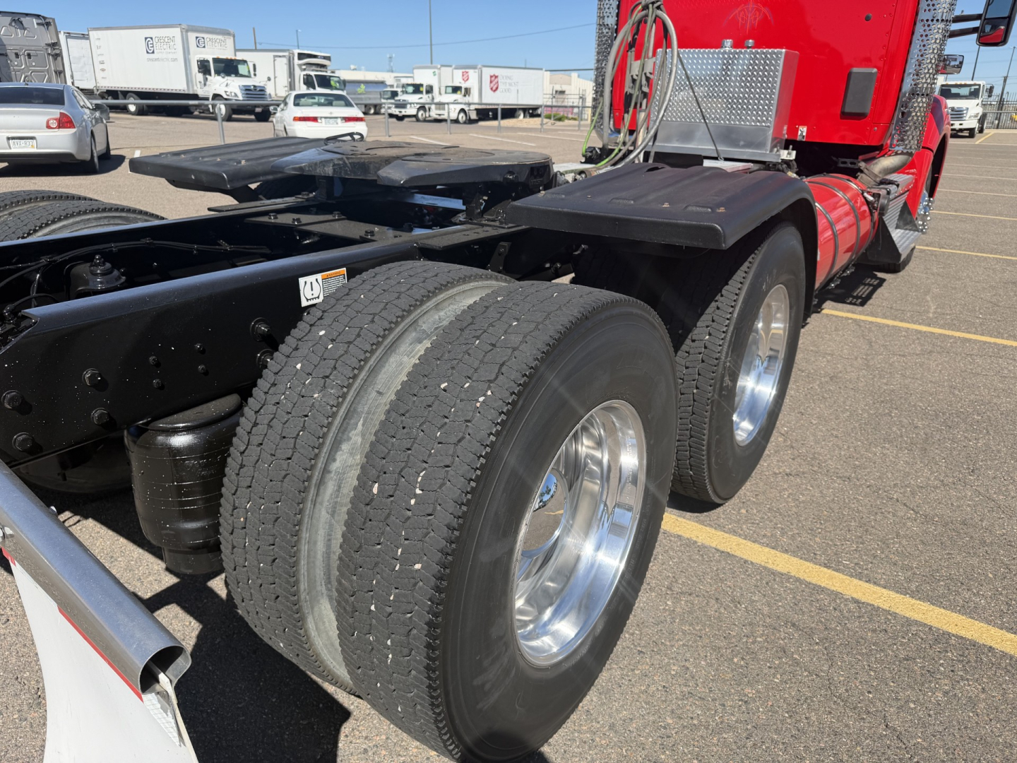 Kenworth T880 daycab rear dual rear axles with dual tires showing chassis and fuel tanks.