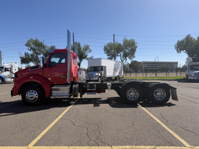 2020 Kenworth T880 conventional daycab truck in a parking lot, side view showing the cab, chassis, and dual rear axles; no visible text on the truck itself.