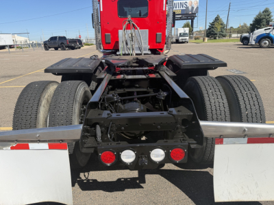Kenworth T880 rear view showing chassis with dual rear axles, fifth wheel, and tail lights; no visible text on components.