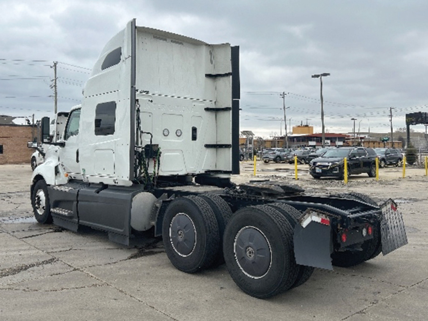 International LT625 tractor in a truck lot showing sleeper cab and rear axle with dual tandem wheels and hitch.