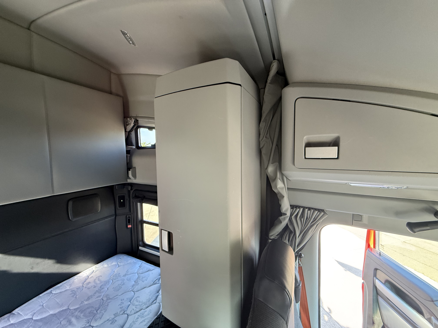 Kenworth T680 sleeper cab interior view showing storage cabinet and window area