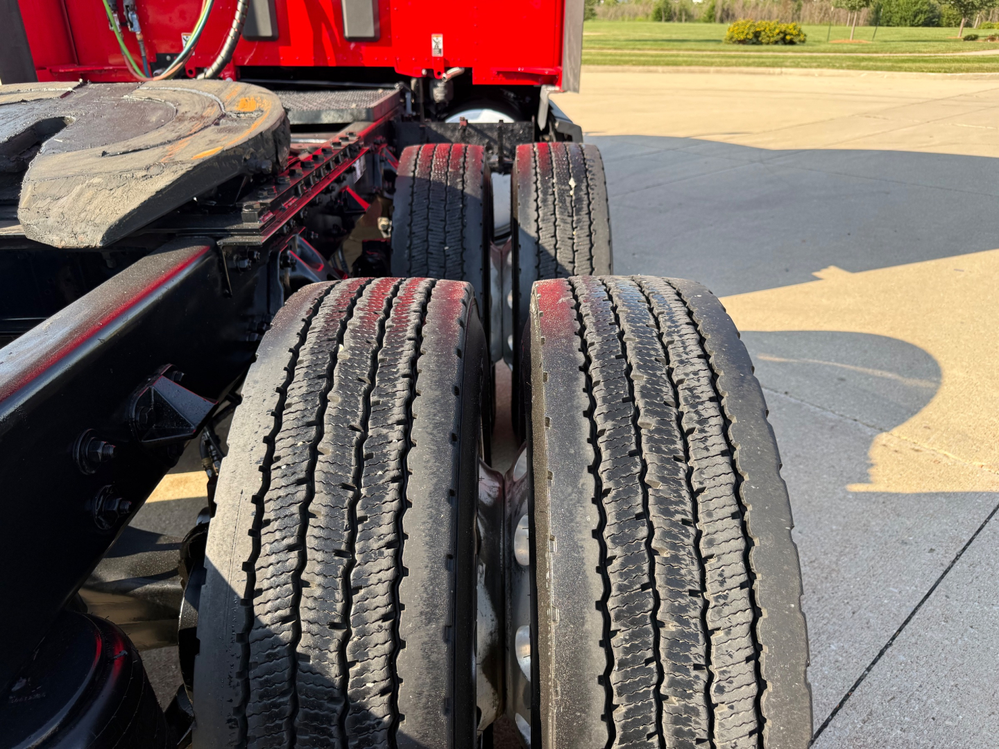Kenworth T680 truck rear wheels with dual tires and red chassis in view