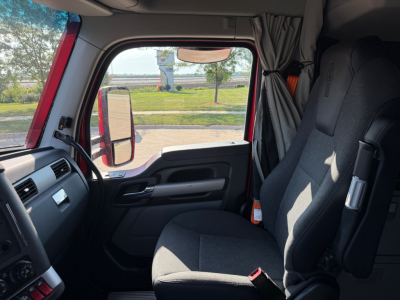 Kenworth T680 truck interior front cab with driver seat, steering wheel, and side window. Visible text: none legible.