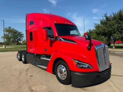 Kenworth T680 tractor in red, side view showing cab, grille, chrome mirrors, front fender, and dual rear wheels.