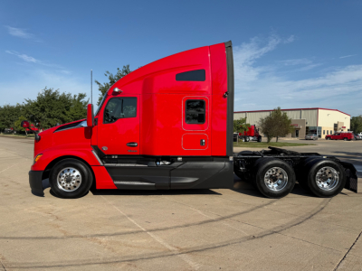 Red 2023 Kenworth T680 tractor-trailer sleeper unit, side profile view with sleeper cab, three rear axles, showing wheels and cab details.