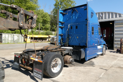 Blue Freightliner Cascadia 125 sleeper tractor chassis with rear assembly and cyan cab, side view showing hitch area and tags.