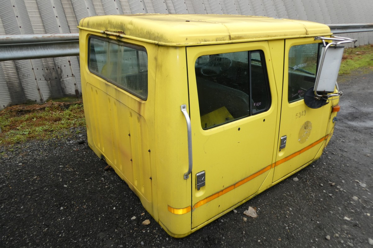 Yellow cab exterior component showing rear and side window with door handles and hinges, quad cab pickup truck part from an International 4700, small details and warning stickers visible.
