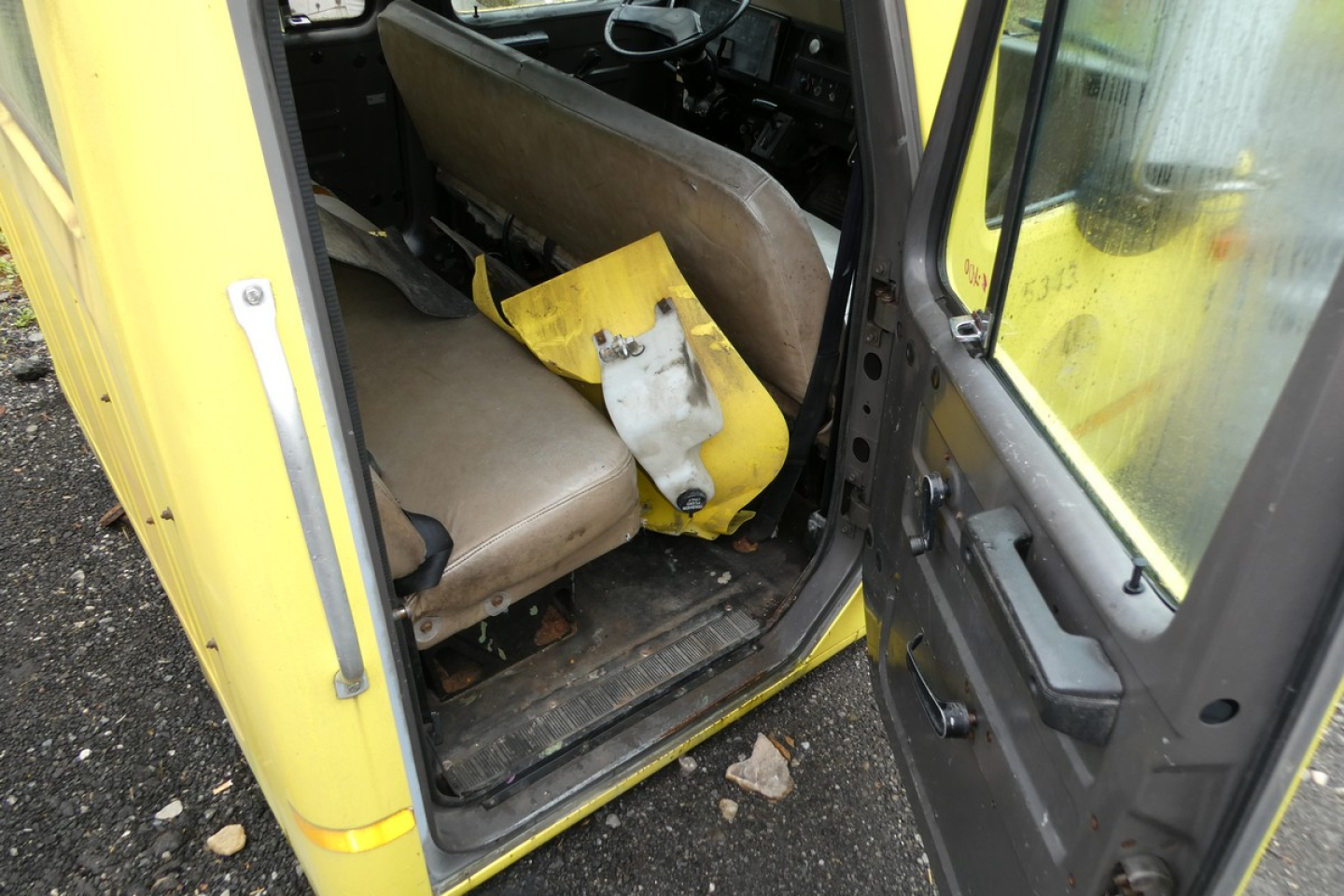 Cab interior showing front seat and worn step area with yellow outer cab door.