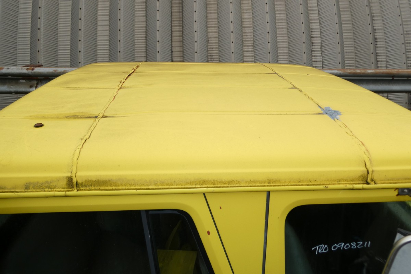 Truck cab roof with yellow paint and visible seam lines, part of a 1993 International 4700 quad cab listing.