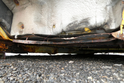 Underbody view of a 1993 International 4700 quad cab cab/frame with rusted undercarriage and metal brackets visible.