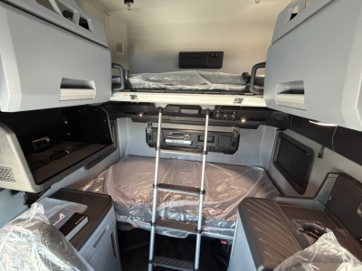  Mack PR64T76H sleeper cab interior showing bunk bed with ladder, storage cabinets, and control panel area.