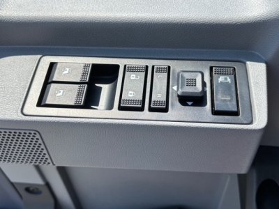 Dashboard controls with multiple switch buttons and window lock icons on a Mack MD7 truck interior