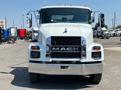 Front view of a white 2026 Mack MD7 truck showing large chrome grille with MACK lettering, rectangular headlights, bumper, and hood ornament.