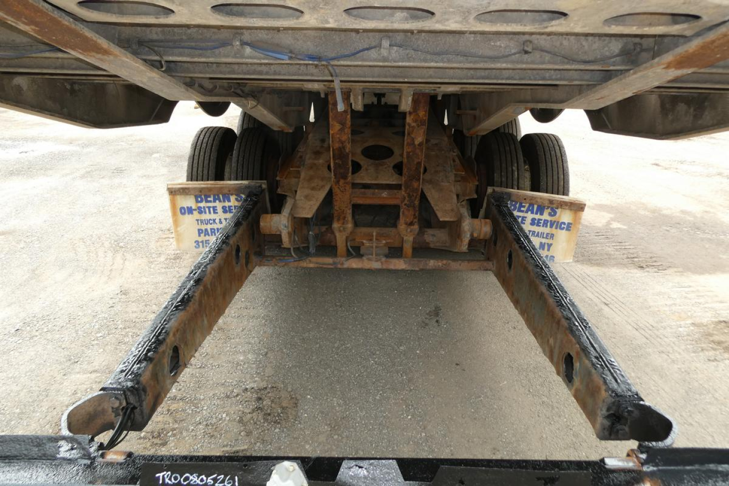 Trailer rear view showing landing gear and frame undercarriage of a 2017 Landoll 930D NGL trailer with rusted steel beams and support brackets.