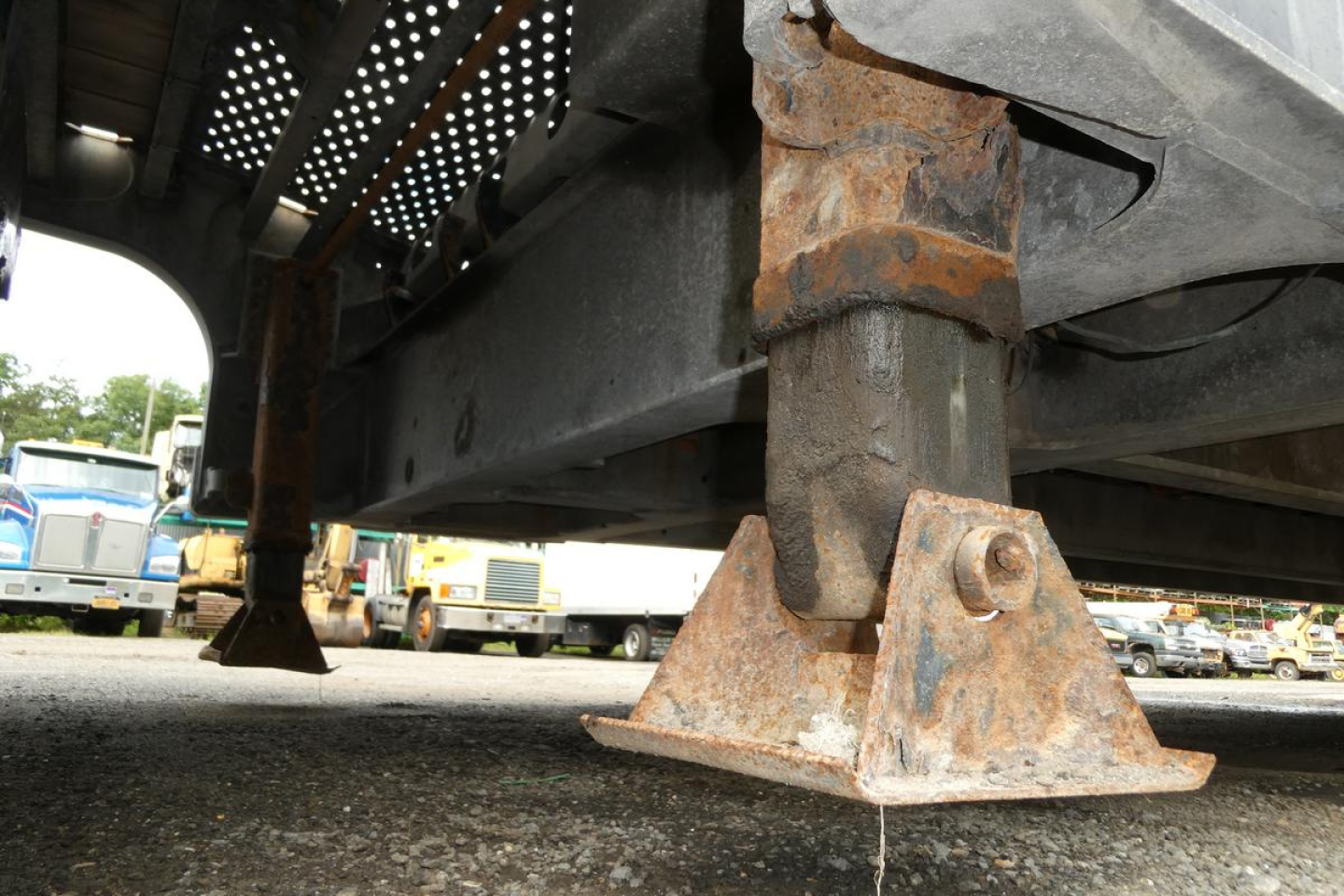 Trailer landing gear and undercarriage showing rusted jack stand and steel frame of a Landoll 930D NGL trailer.