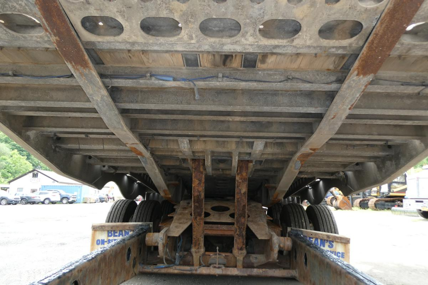 Trailer underside showing landing gear and dual axles with rust-free-looking metal beams and tires. 2017 Landoll 930D NGL trailer underside view.