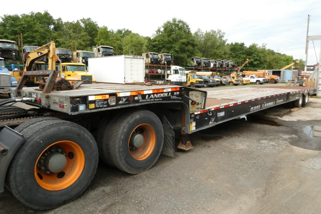 Landoll 930D NGL trailer showing dual rear axles with orange rims and flatbed deck.