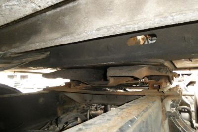 Trailer axle area showing suspension components and underside of Landoll 930D NGL trailer with visible leaf springs and frame.