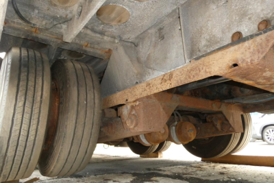 Landoll 930D NGL trailer undercarriage showing dual rear tires and rusted underframe components.