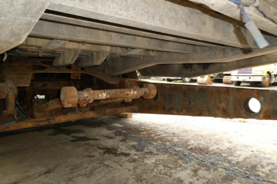 Underbody view of a Landoll 930D NGL trailer showing rusty undercarriage and axle components.