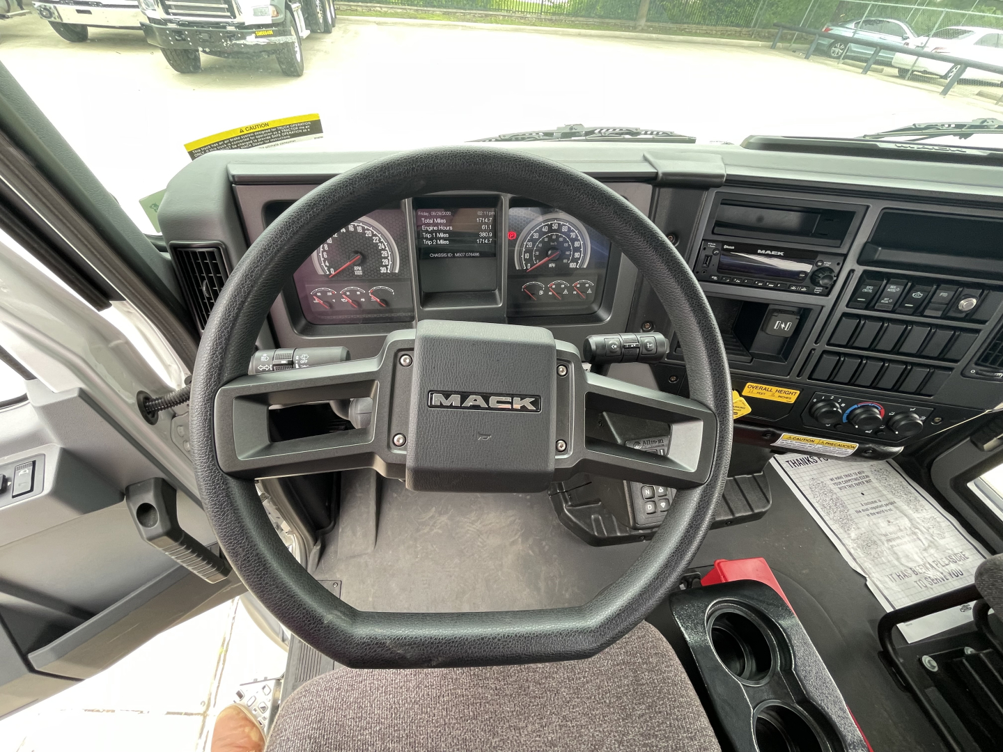 Steering wheel and dashboard inside a 2025 Mack MD7 cab showing Mack logo on steering wheel and instrument cluster.