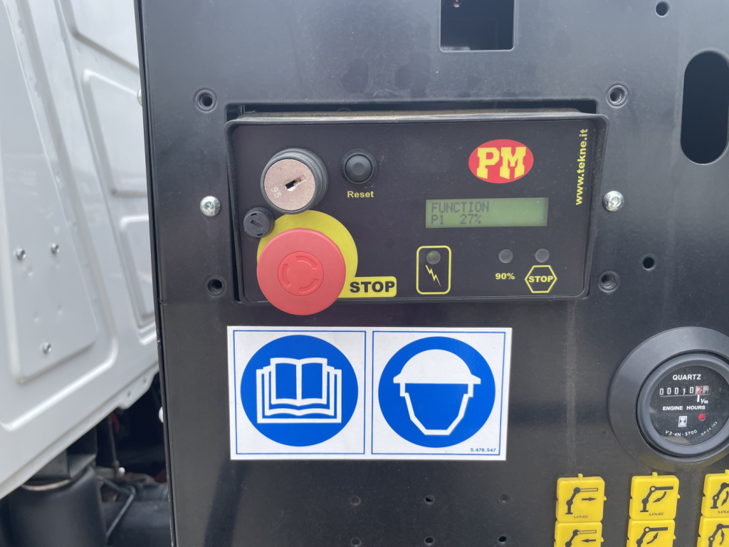 Panel with PM controller showing STOP button, yellow round push, LCD display, two blue safety/hand icons stickers, and a gauge; 50% STOP text and various labels visible.