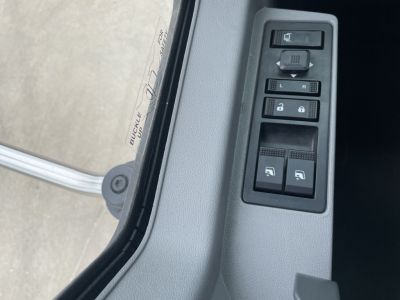 Truck interior: door control panel with window/lock switches and mirror controls adjacent to door frame; part of a 2025 Mack MD7 listing.