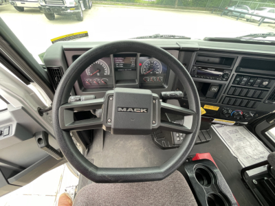 Steering wheel and dashboard inside a 2025 Mack MD7 cab showing Mack logo on steering wheel and instrument cluster.