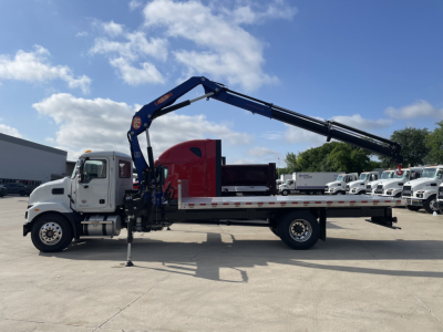 MD7 Mack boom truck with long blue crane, white cab, red rear body, black railing, and stabilizer legs in a parking lot.