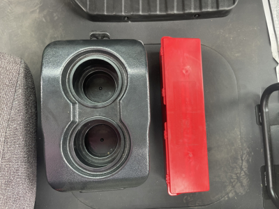 Twin circular fluid reservoirs in the cab area with a red rectangular component beside them.