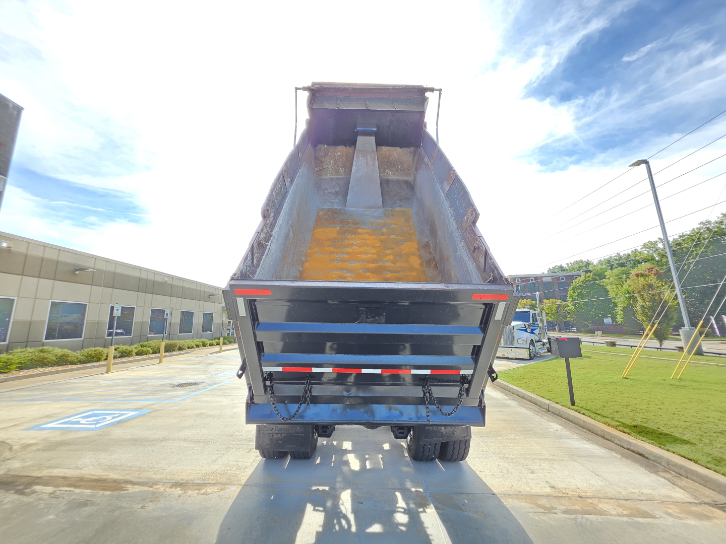 Dump truck bed of a 2022 Mack GRANITE with open cargo area, rear view showing dump bed and taillights.
