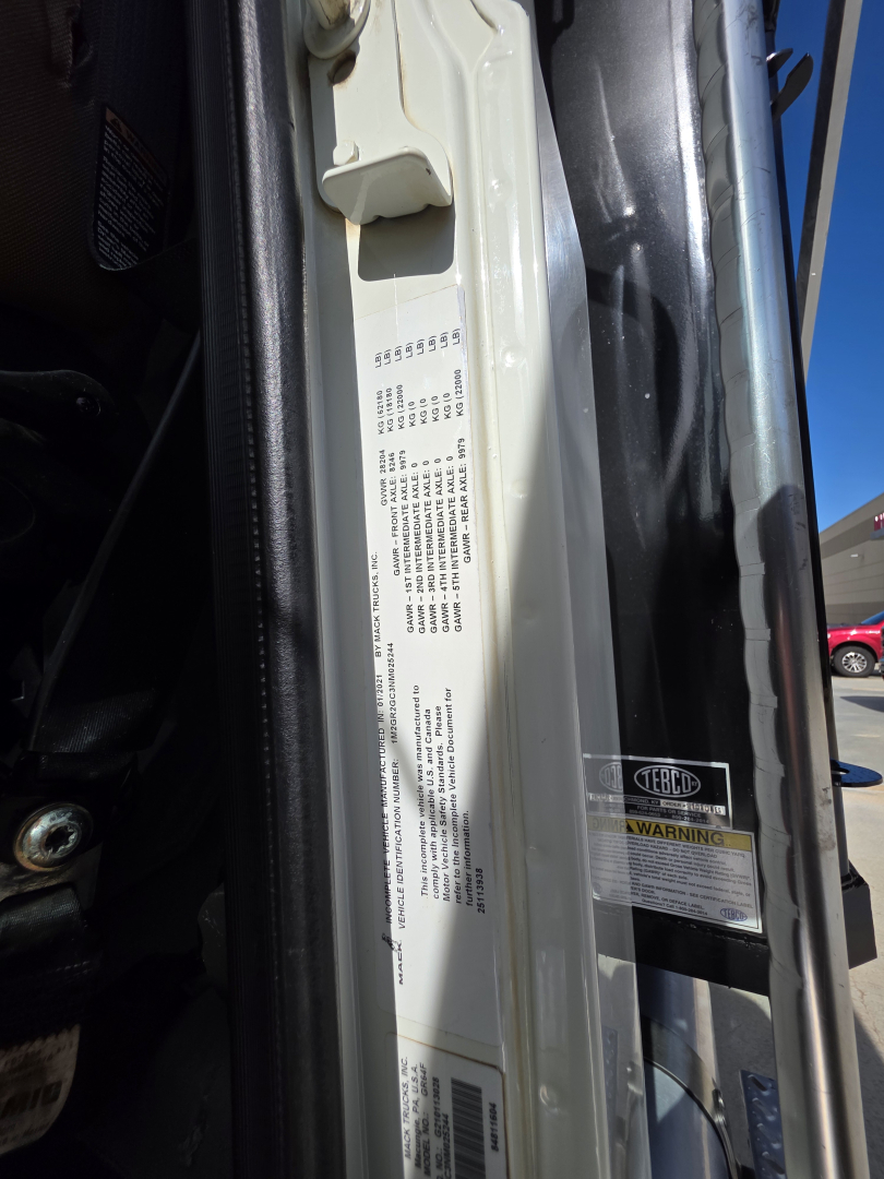 Label on door frame with vehicle VIN and stock number; near a warning sticker and data plate. Text includes: 555555?; small block of dense text typical of tire or GVWR/axle information. Visible: a vertical white data plate with multiple lin