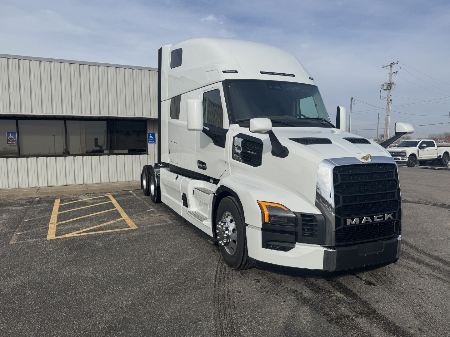 Mack PR64T76H tractor-trailer cab in white, front-right view, with black grille and chrome accents.