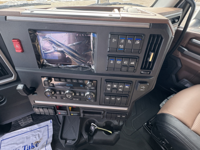 Truck dash showing touchscreen display, climate controls, and switches in Mack PR64T76H interior.