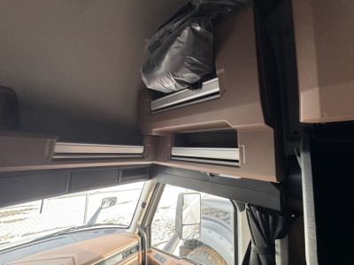 Truck interior cab overview showing overhead storage compartments and a window day view, Mack PR64T76H listing.
