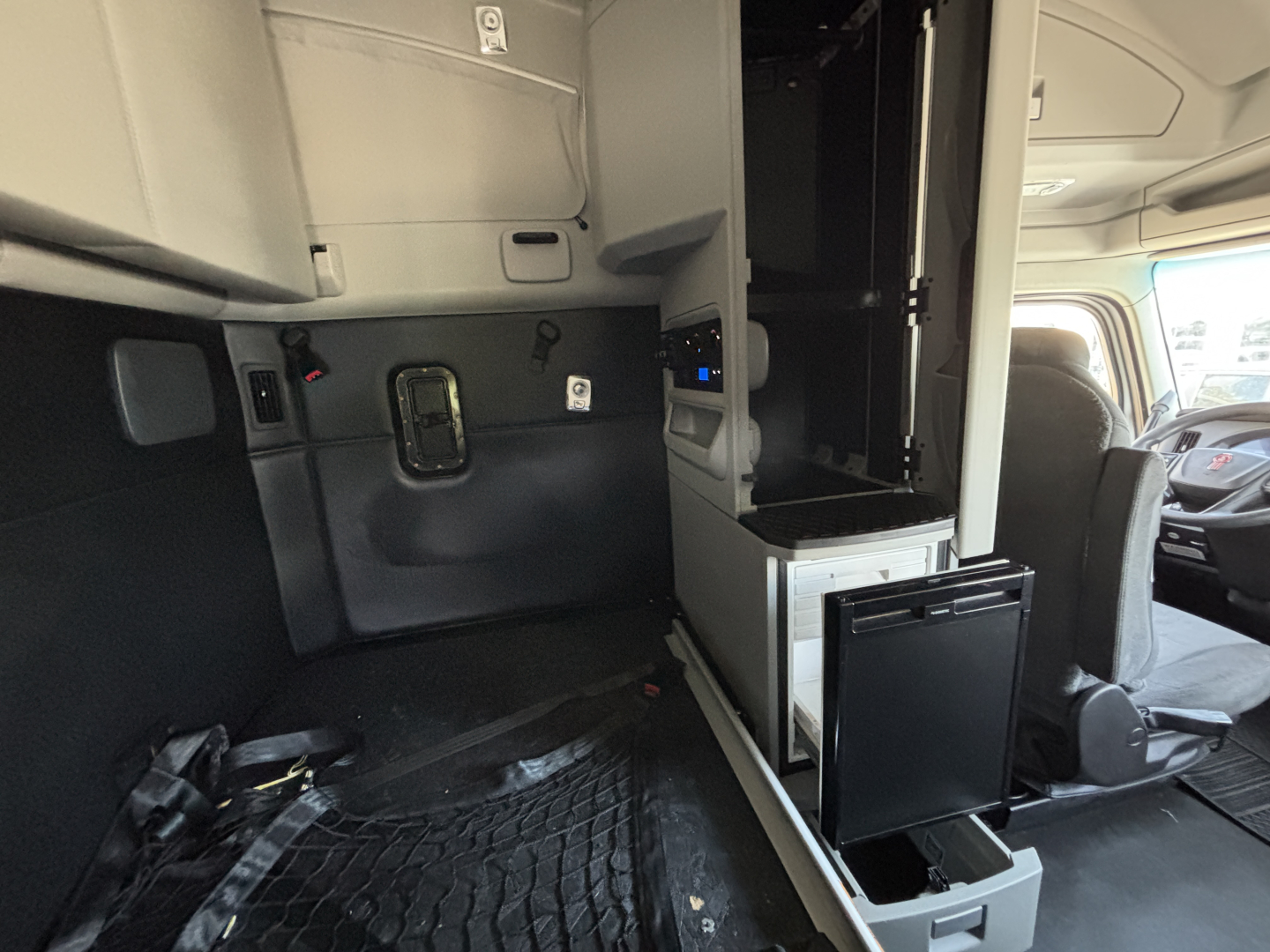 Kenworth T680 interior cab area showing sleeper storage and dashboard entry with controls