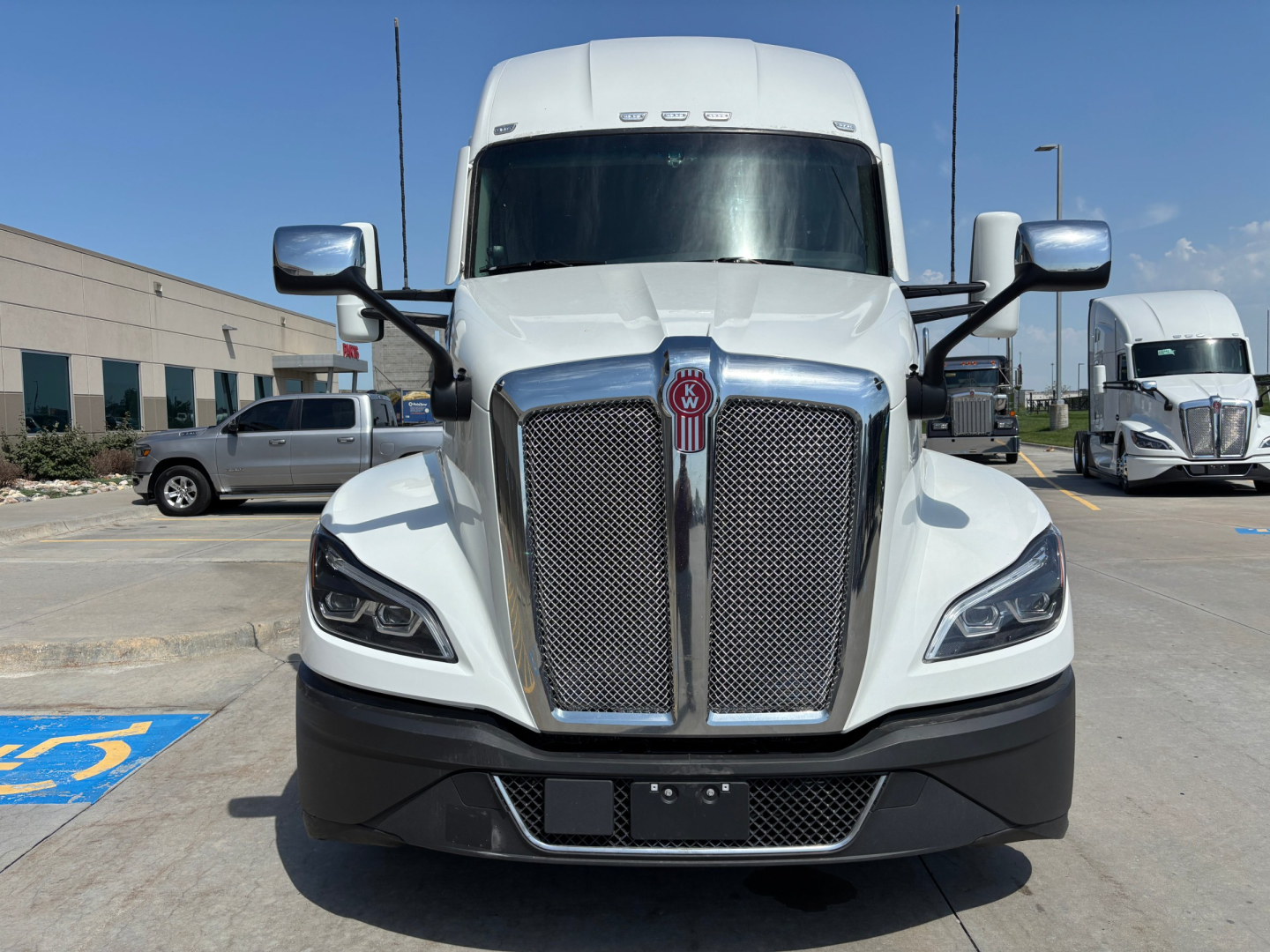Front view of a white 2022 Kenworth T680 sleeper cab truck showing grille, headlights, and side mirrors.