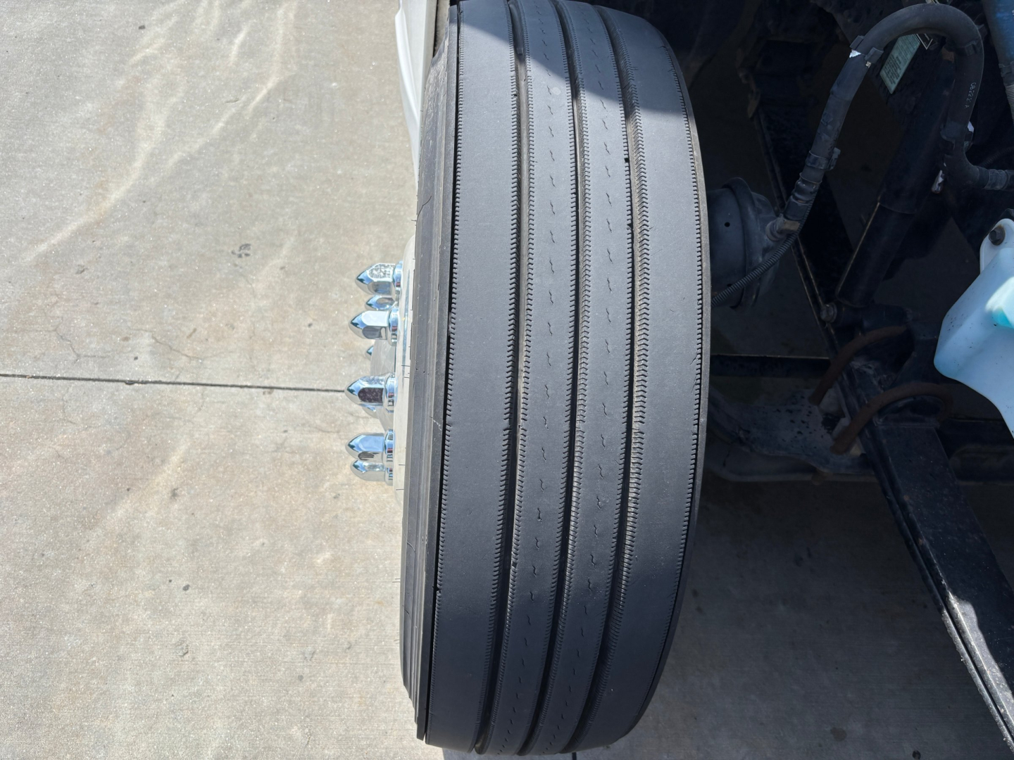 Diesel truck rear wheel and dual-tire setup on Kenworth T680; visible wheel, lug nuts, and part of suspension/axle area.