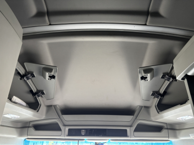 Cab interior ceiling view of a 2022 Kenworth T680 sleeper truck showing overhead storage compartments and sun visors.