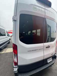 Ford Transit 350 HD XLT rear view showing Transit badge and rear tailgate, white exterior, van with tinted windows.