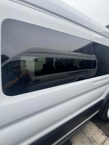 Ford Transit van side panel with tinted window reflecting person taking photo