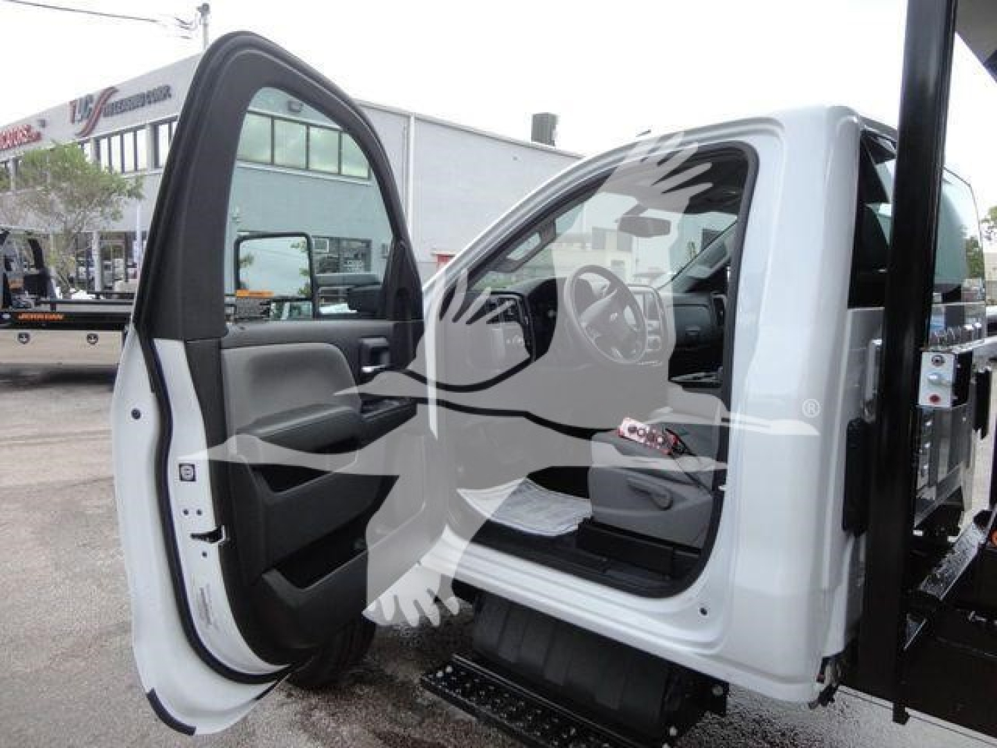 Truck cabin with open driver door and step bar visible; Silverado 5500HD cab interior with steering wheel and dashboard glimpsed