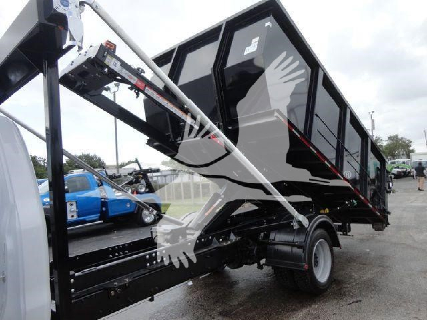 Chevrolet Silverado 5500HD dump body on a roll-off truck showing rear wheel and hydraulic arm assembly