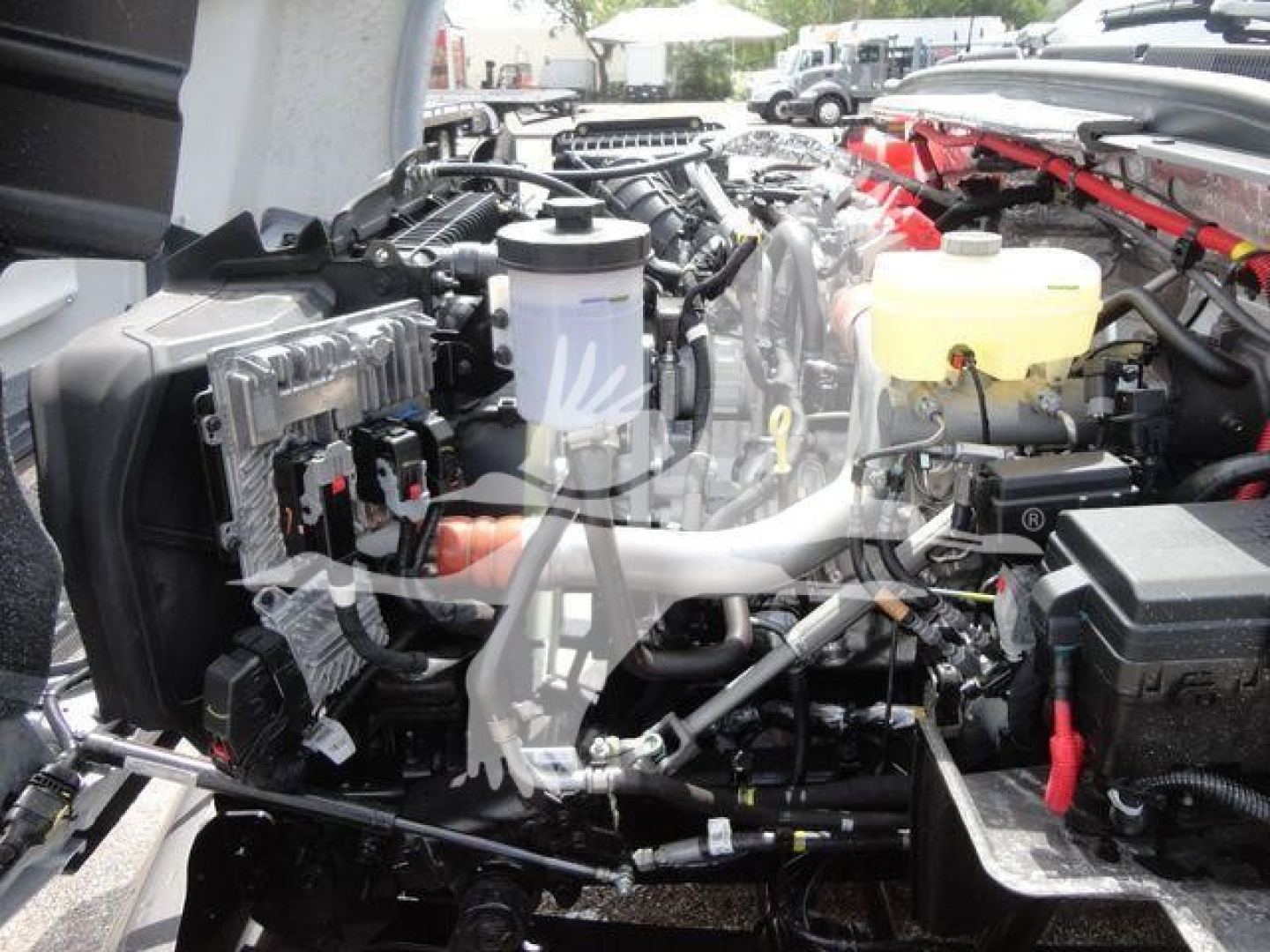 Engine bay of a 2023 Chevrolet Silverado 5500HD in-service with visible components: brake fluid reservoir, coolant reservoir, air intake lines, electrical modules, hoses, and a yellow master reservoir.