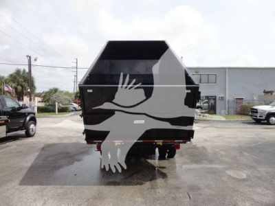 Tractor-trailer style dump bed on a Silverado 5500HD chassis showing a black dump bed with white bird graphic.