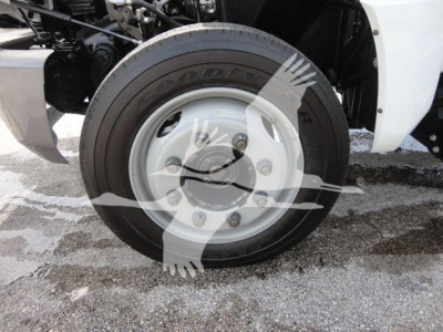 Front wheel and tire of a 2023 Chevrolet Silverado 5500HD rolloff truck showing Goodyear tire and silver hubcap.