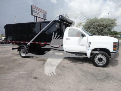 Truck body showing a white Chevrolet Silverado 5500HD cab and a black roll-off container withReflective decals.