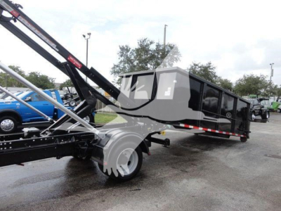 Truck bed with dump/dump trailer and hydraulic arm showing a Silverado 5500HD in-service. Rolloff truck body with black panels and side rails.